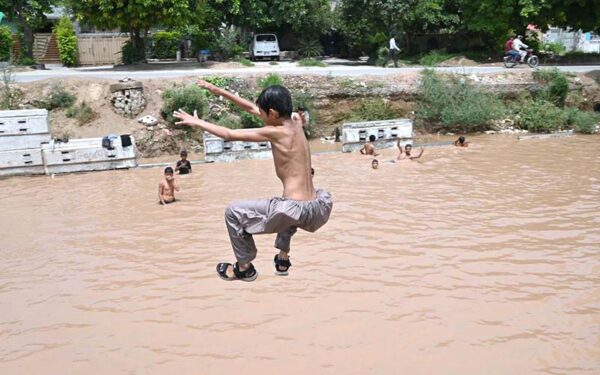 Children play in rainwater pond on IGP Road
