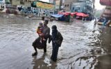 Family navigates flooded road during heavy rainfall